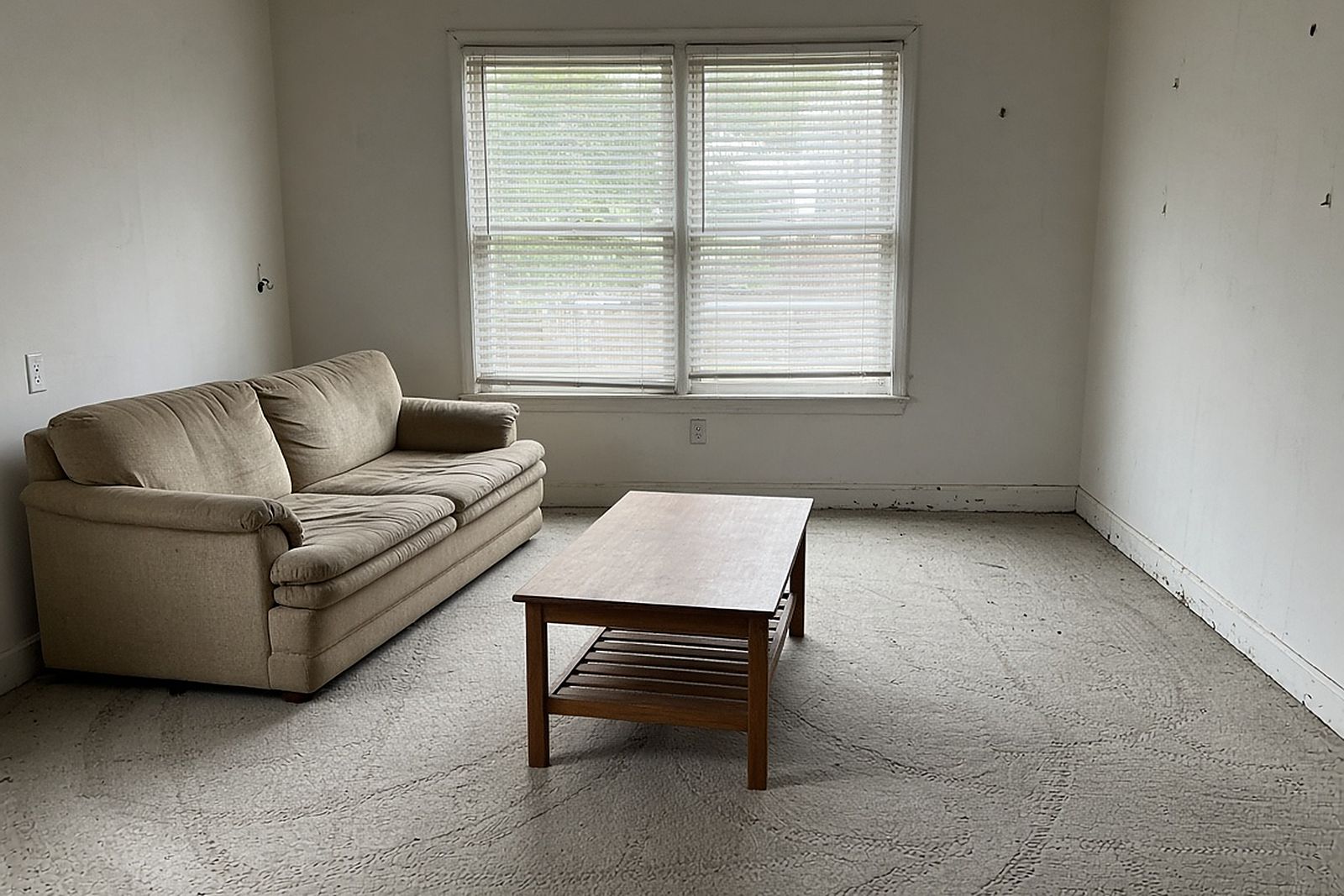 Cleared living room with a sofa and coffee table and the floor visible again